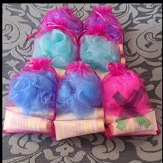 several bags of soaps are sitting on the floor with pink and blue hair in them