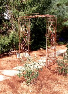 an iron garden arbor in the middle of a yard