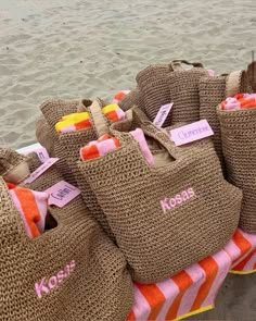 several burlocks with name tags on them sitting in the sand at the beach