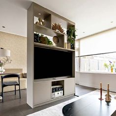 a large flat screen tv mounted to the side of a wall in a living room