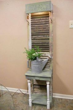 a potted plant sitting on top of a wooden shelf next to a window with shutters