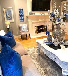 a living room filled with furniture and a flat screen tv mounted on the wall above a fireplace