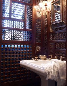 a bath room with a sink and a light hanging from the ceiling next to a window