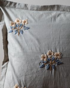 an embroidered pillow with flowers on it