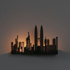 the silhouette of a city is shown at sunset in this photo, it appears to be made out of paper