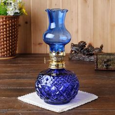 a blue glass vase sitting on top of a wooden table next to a white towel