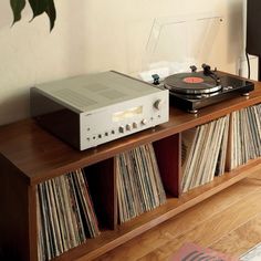 a record player sitting on top of a wooden shelf