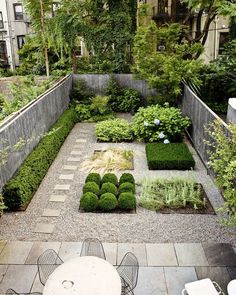 an outdoor garden is shown with various plants and shrubs in the center, including boxwood