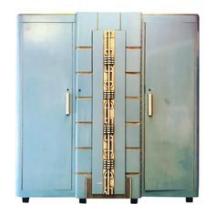 two blue cabinets with gold handles and designs on the doors are standing side by side