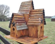 a wooden bird house with stars on the roof