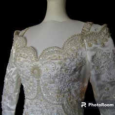 the back of a white wedding dress with gold beading and sequins on it