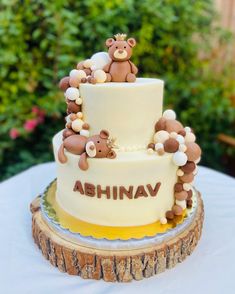 a three tiered cake decorated with teddy bears and the word abhnav on it