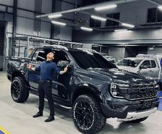 a man standing next to a truck in a garage