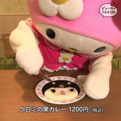 a hello kitty doll is eating cake with chopsticks