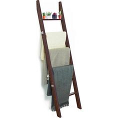 a wooden ladder shelf with towels and potted plants on the top, against a white background