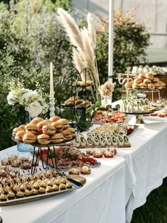 a table topped with lots of pastries on top of a white table cloth covered field