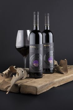 three bottles of wine sitting on top of a wooden board