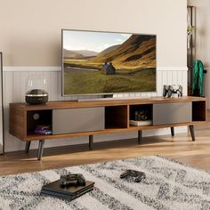 a flat screen tv sitting on top of a wooden entertainment center in a living room