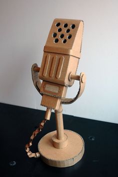 a wooden model of a microphone on a black table