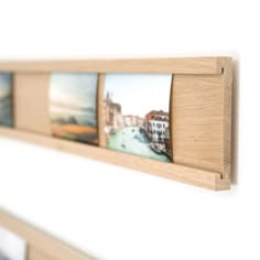 a wooden shelf with pictures hanging on it's sides and the bottom half is made out of wood