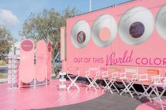 a pink trailer with chairs and tables in front of it that says out of this world colors