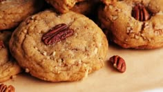 a pile of cookies with pecans on top