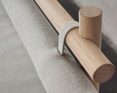 a close up of a wooden handle on a curtain rod with fabric attached to it