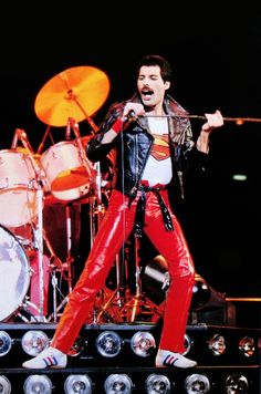 a man in red pants and leather jacket on stage