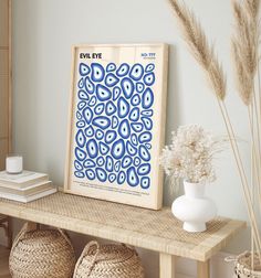 a blue and white art print sitting on top of a wooden table next to baskets