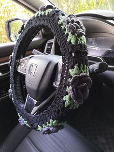 a car steering wheel cover with crocheted flowers on the front and back sides