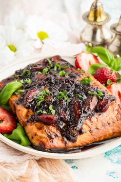 a white plate topped with meat covered in fruit