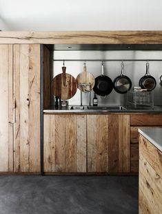 a kitchen with wooden cabinets and hanging pans