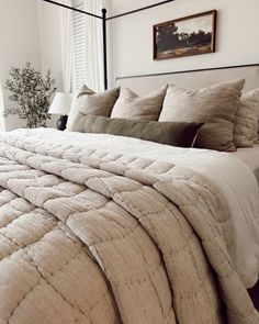 a large bed with pillows and blankets in a bedroom