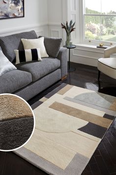 a living room with a gray couch and white chair next to a rug on the floor