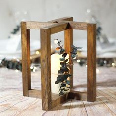 a small wooden lantern with a lit candle in it on top of a wood table