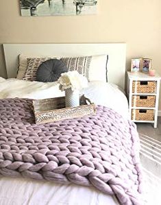 a bedroom with a bed, nightstands and pictures on the wall above it is shown