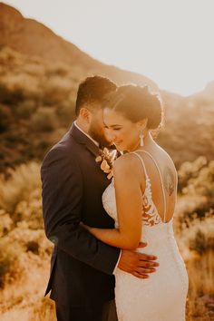 a bride and groom embracing in the desert