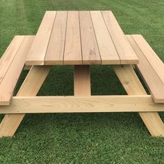 a wooden picnic table sitting in the grass