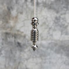 a metal object hanging from a rope on a wall