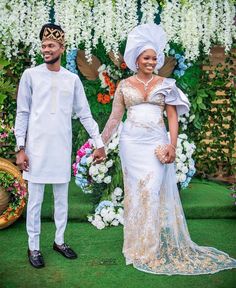 an african couple dressed in traditional attire holding hands