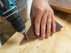 a person using a drill to cut wood