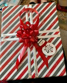 a present wrapped in red and grey paper with a bow