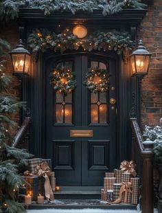 a black front door decorated with christmas wreaths and wrapped presents under the lights, surrounded by evergreen trees