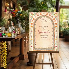 a welcome sign sitting on top of a wooden easel in front of a table