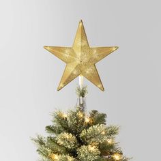 a gold star decoration on top of a christmas tree