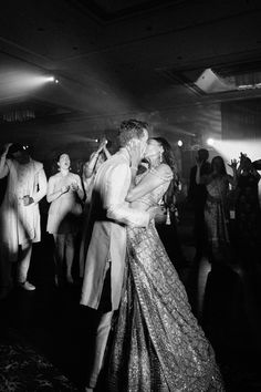 black and white photograph of two people dancing in front of a group of people on the dance floor