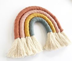 a multicolored rug with tassels hanging from the side on a white wall