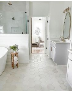 a white bathroom with hexagonal tile flooring