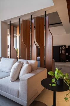 a white couch sitting next to a black table in a living room with wooden paneling on the walls