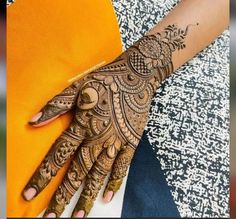 a woman's hand with henna tattoos on it